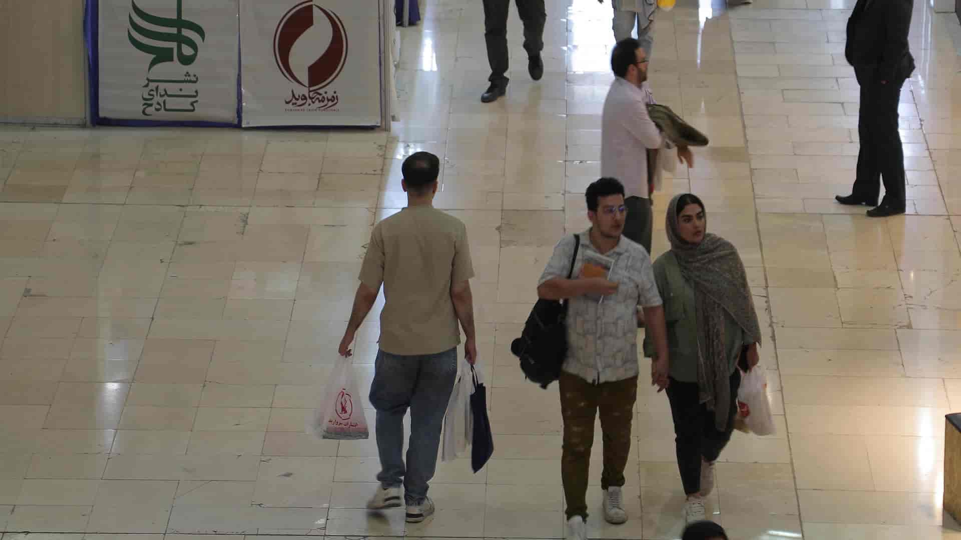 مرد با کیسه خرید در نمایشگاه کتاب